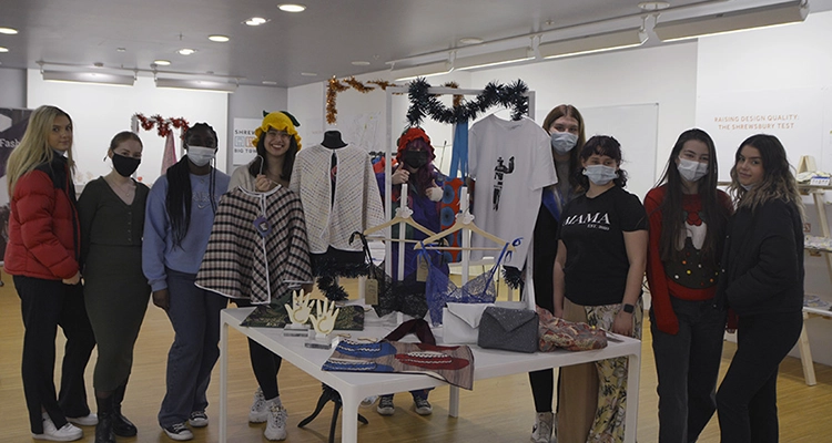 A class of Fashion & Textiles students with the items on display in their pop-up shop